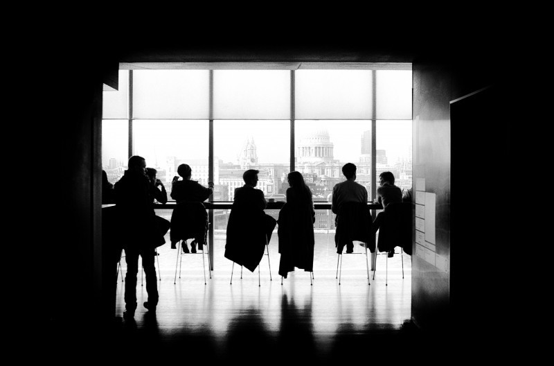 black and white image of people sitting in conference room
