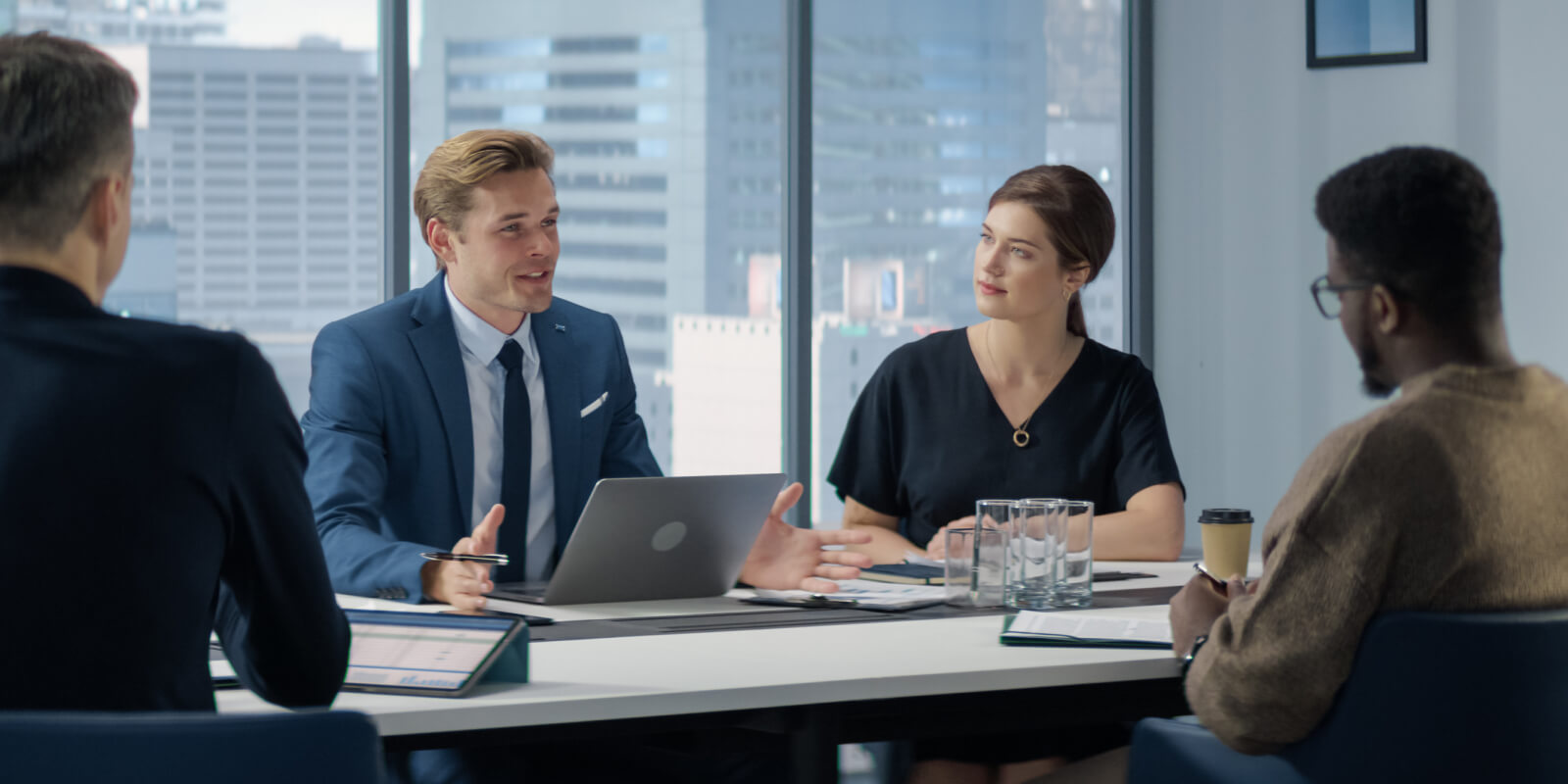 Diverse professional team reviewing data on a laptop in a meeting about technological change