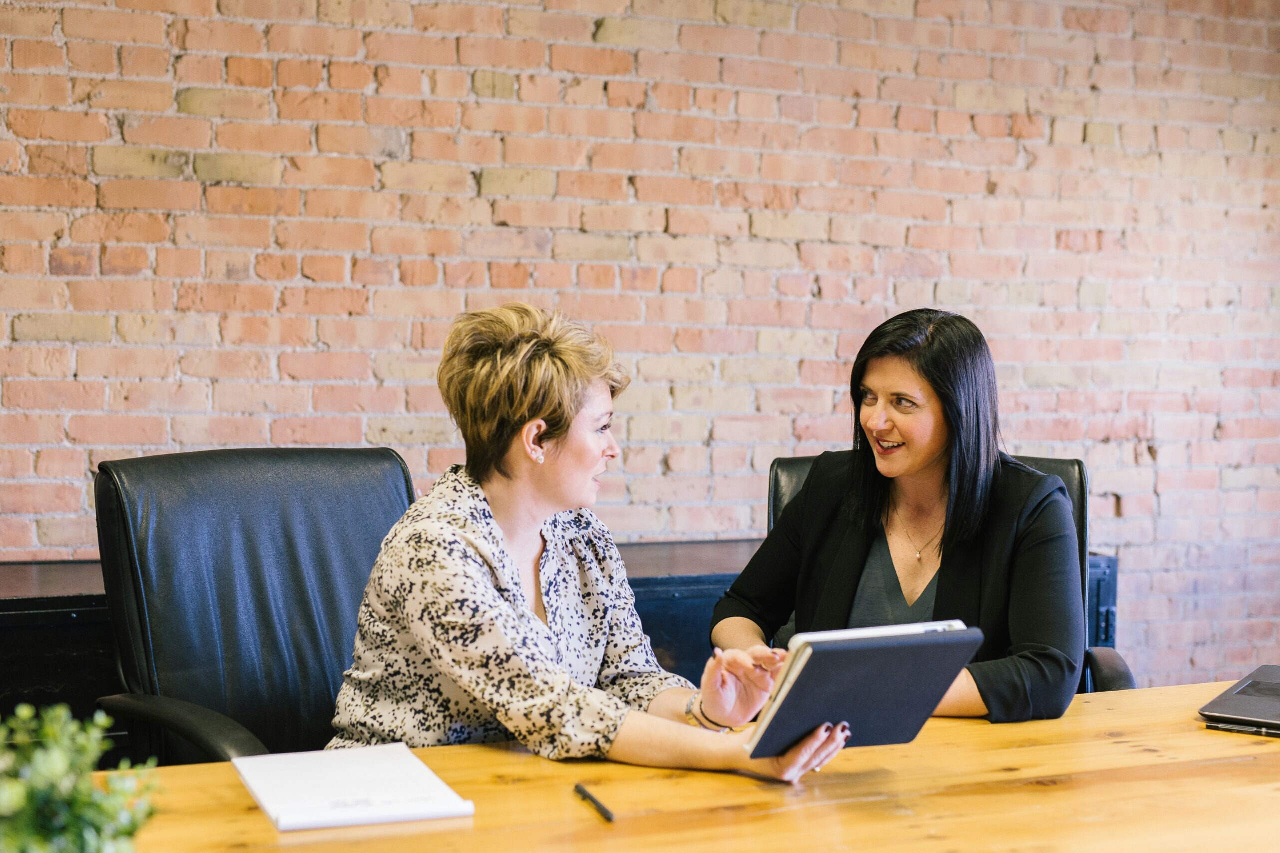 HR manager and employee reviewing a plan for managing mental health absence on a tablet